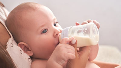 Ein Baby trinkt aus einer Flasche.