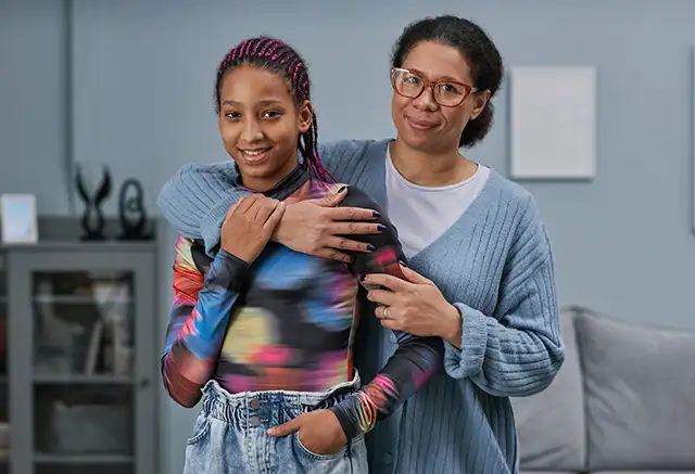 A mother and daughter embrace.
