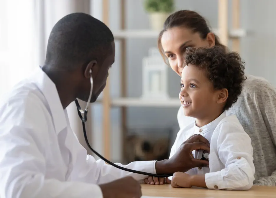 A doctor listens to a child's heart with a stethoscope.