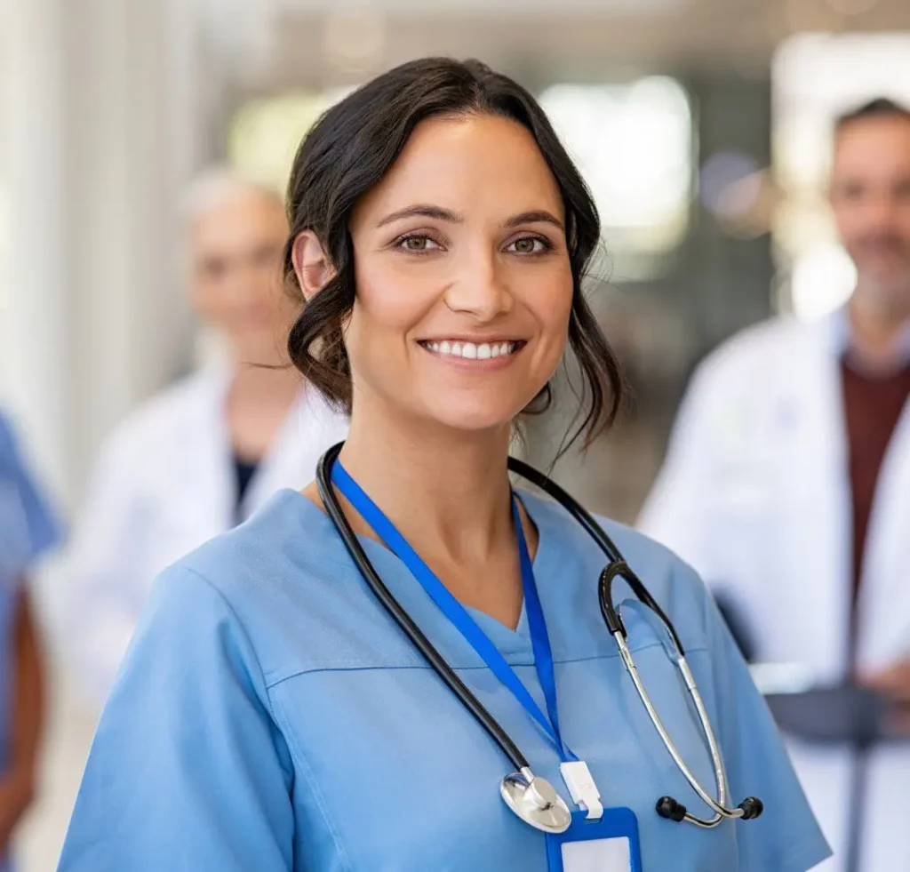 A female medical professional smiles.